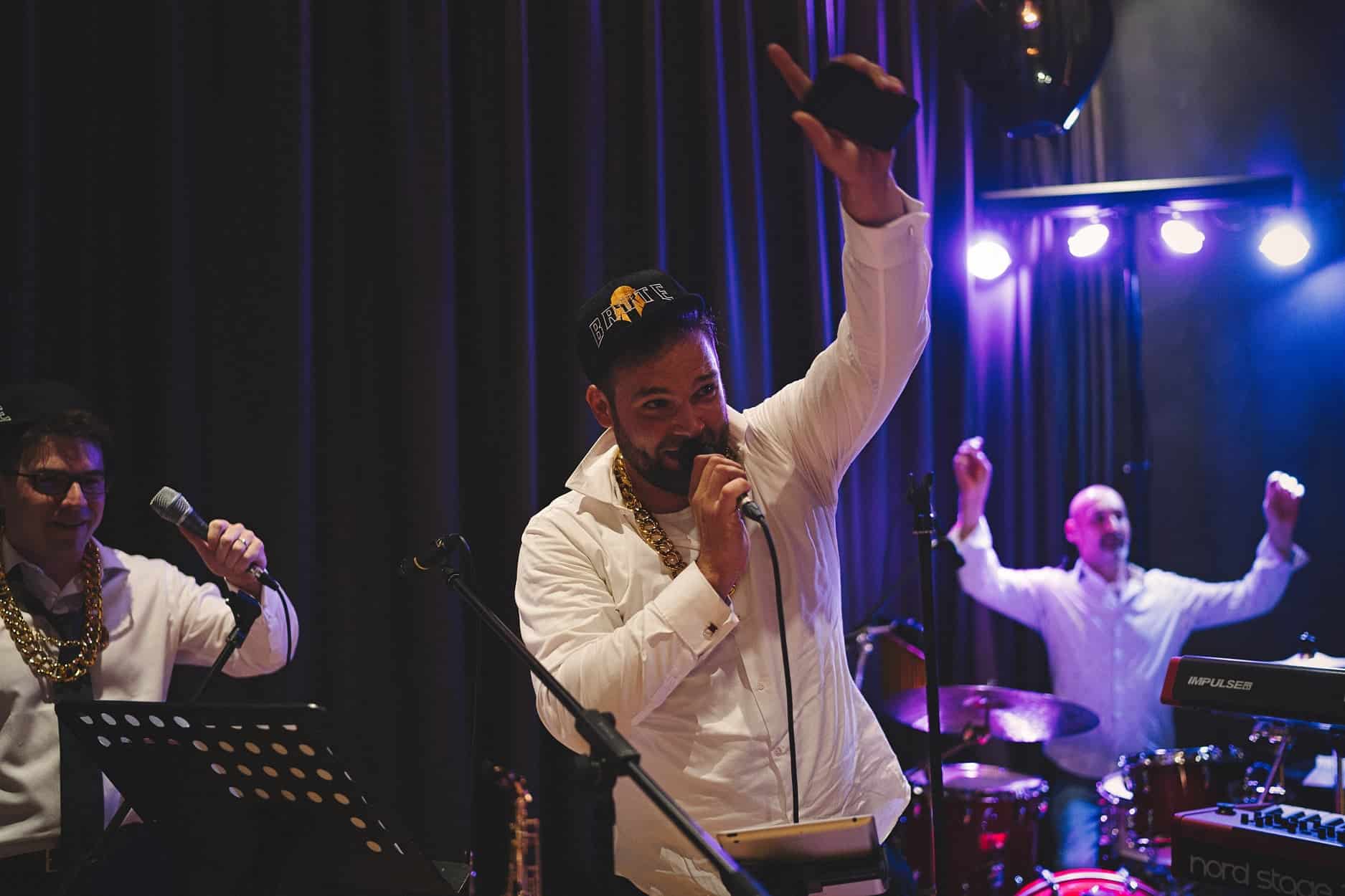 The Cover Band na pódiu — saxofonista, zpěvačka a bubeník při živém vystoupení
