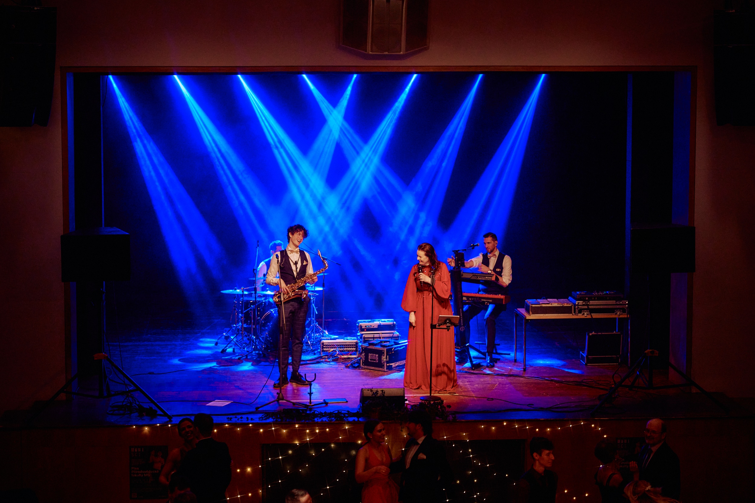 The Cover Band na pódiu — celý sál s tančícími hosty a modrými světly